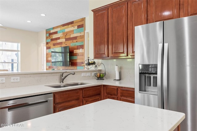 kitchen featuring tasteful backsplash, sink, light stone counters, and stainless steel appliances