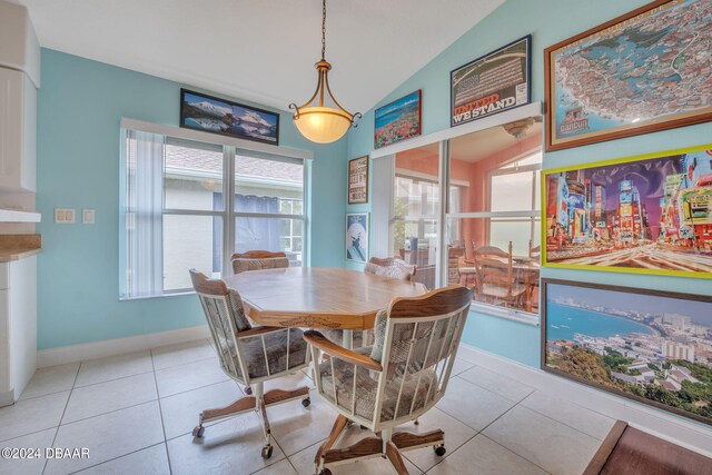 dining space featuring light tile patterned floors and vaulted ceiling