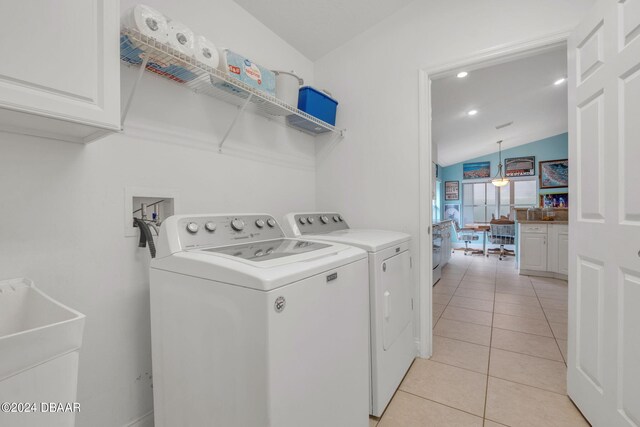 laundry area featuring cabinets, light tile patterned floors, washing machine and clothes dryer, and sink