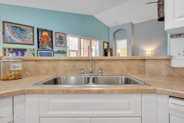 kitchen featuring white cabinetry, sink, vaulted ceiling, and white dishwasher