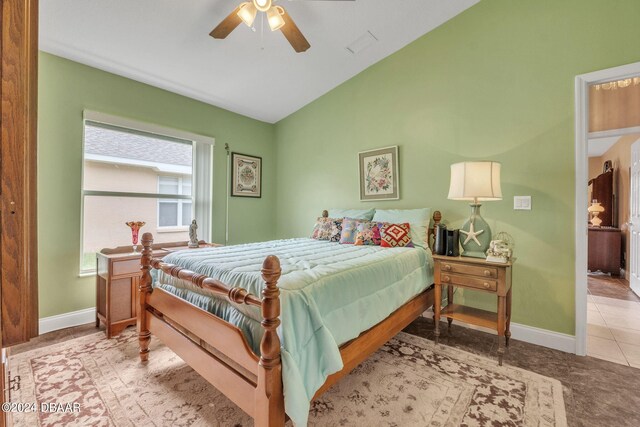 tiled bedroom featuring lofted ceiling and ceiling fan