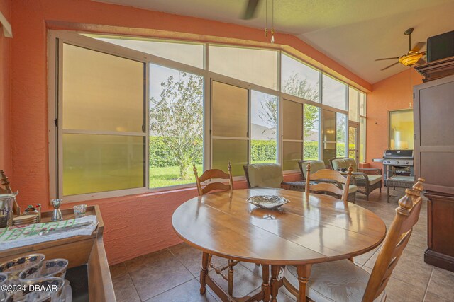 dining area featuring ceiling fan, light tile patterned floors, and lofted ceiling