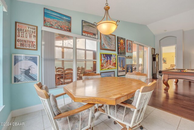 tiled dining space with pool table and vaulted ceiling