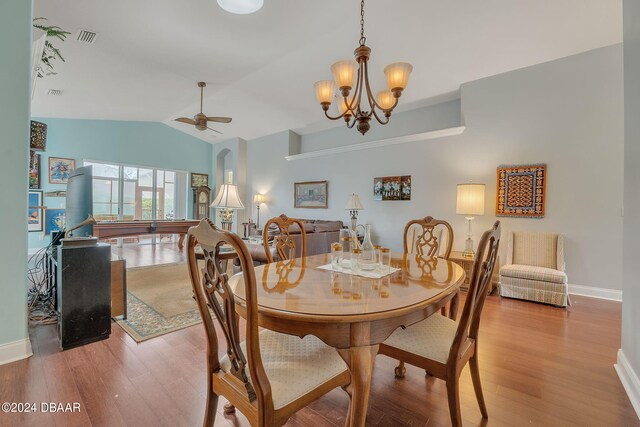 dining room with light hardwood / wood-style floors, ceiling fan with notable chandelier, and lofted ceiling