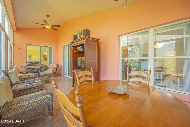 dining room with ceiling fan, tile patterned flooring, and lofted ceiling