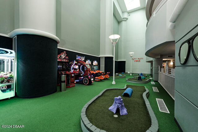 350 N Atlantic Ave Unit 2124, Daytona Beach, FL 32118 - recreation room with a high ceiling, golf simulator, and carpet flooring