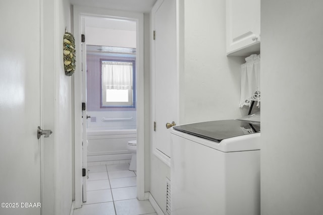 laundry room with cabinets, washer / dryer, and light tile patterned floors