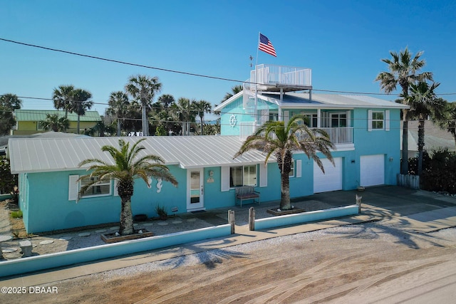 view of front of home featuring a balcony and a garage