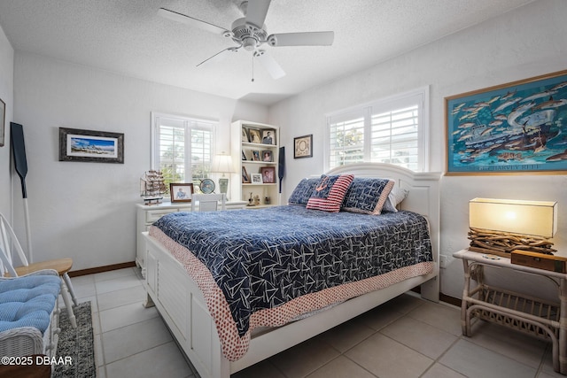 bedroom with ceiling fan, light tile patterned floors, and a textured ceiling