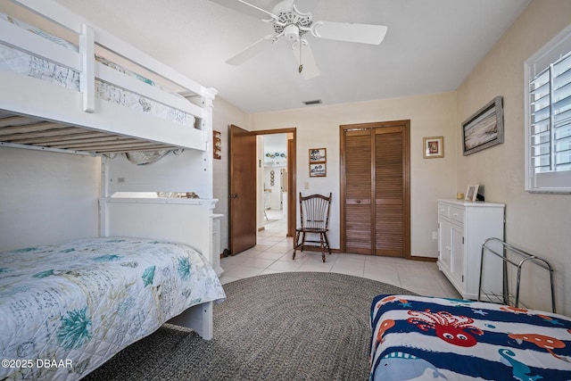 tiled bedroom featuring ceiling fan and a closet