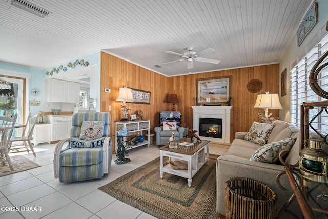 tiled living room featuring wooden walls, wood ceiling, and ceiling fan