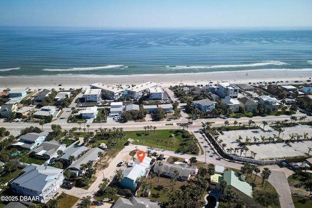 birds eye view of property with a water view and a beach view