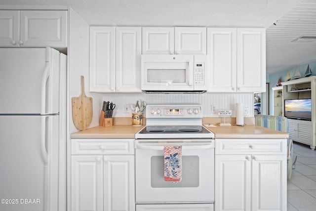 kitchen with white cabinetry, light tile patterned floors, and white appliances