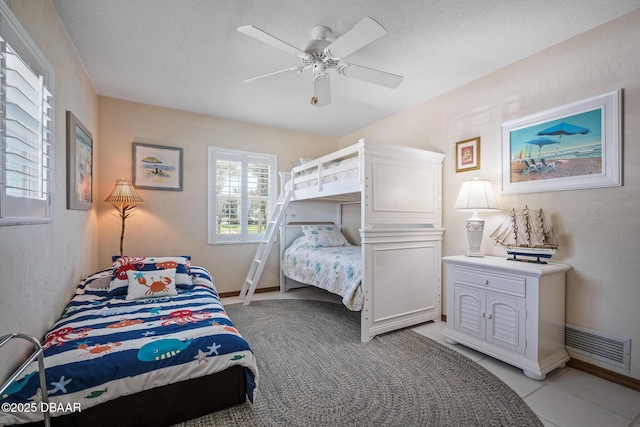 tiled bedroom featuring a textured ceiling and ceiling fan