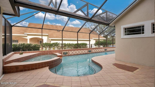 view of swimming pool featuring glass enclosure, a patio area, and an in ground hot tub