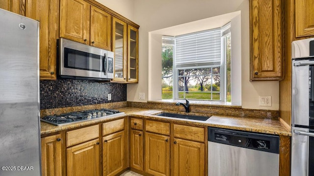 kitchen featuring backsplash, sink, and appliances with stainless steel finishes