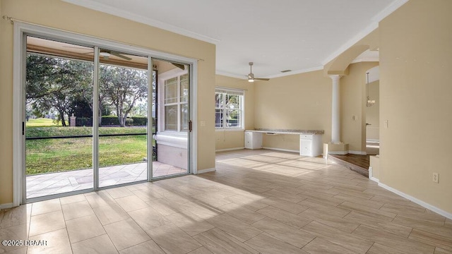 doorway featuring light wood-type flooring, ornate columns, ceiling fan, and ornamental molding