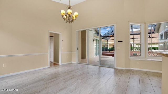 spare room with a high ceiling and a notable chandelier