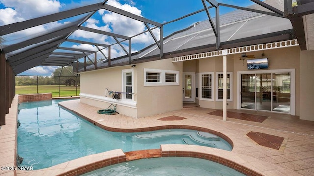 view of swimming pool featuring a patio area, a lanai, and an in ground hot tub