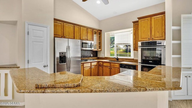 kitchen featuring light stone countertops, sink, and stainless steel appliances