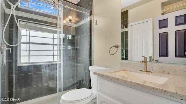 bathroom with vanity, a shower with shower door, and toilet