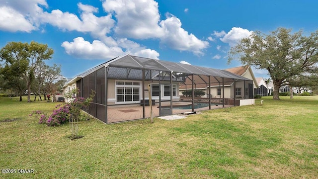 rear view of property featuring a lanai, a yard, and a patio