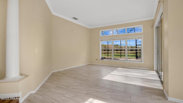 unfurnished room with decorative columns and ornamental molding