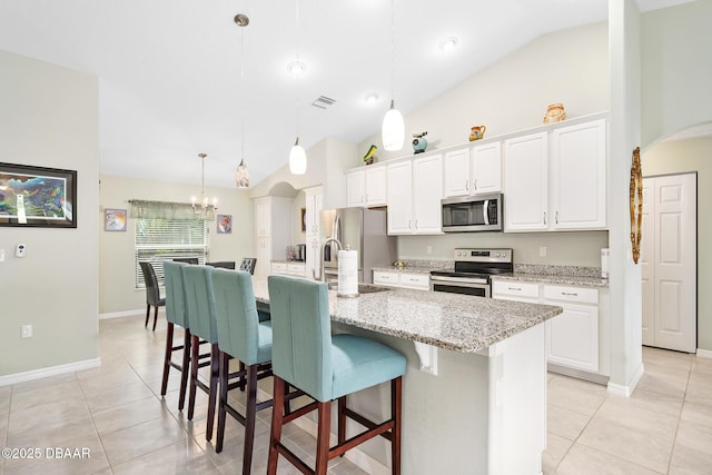 118 Bird Of Paradise Dr, Palm Coast, FL 32137 - kitchen featuring appliances with stainless steel finishes, light tile patterned flooring, a breakfast bar area, and high vaulted ceiling