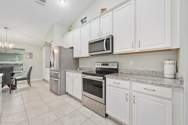 118 Bird Of Paradise Dr, Palm Coast, FL 32137 - kitchen with appliances with stainless steel finishes, lofted ceiling, a chandelier, white cabinets, and light tile patterned floors