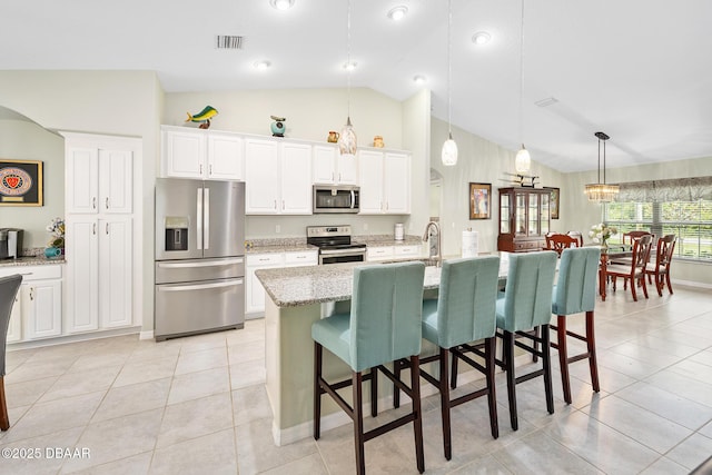 118 Bird Of Paradise Dr, Palm Coast, FL 32137 - kitchen featuring appliances with stainless steel finishes, a kitchen breakfast bar, light tile patterned floors, pendant lighting, and high vaulted ceiling