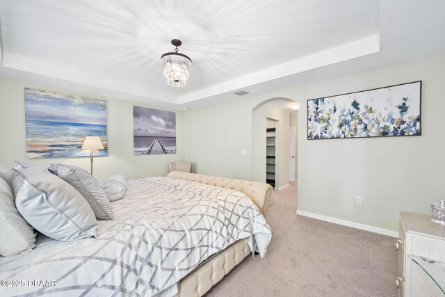 118 Bird Of Paradise Dr, Palm Coast, FL 32137 - bedroom featuring a tray ceiling, arched walkways, carpet, and a chandelier