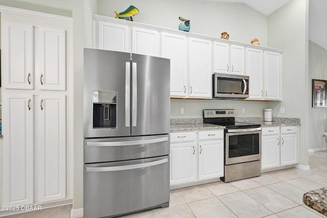 118 Bird Of Paradise Dr, Palm Coast, FL 32137 - kitchen with appliances with stainless steel finishes, white cabinets, light tile patterned floors, and light stone counters