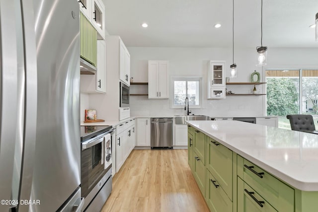 kitchen featuring a kitchen island, white cabinets, green cabinetry, and stainless steel appliances