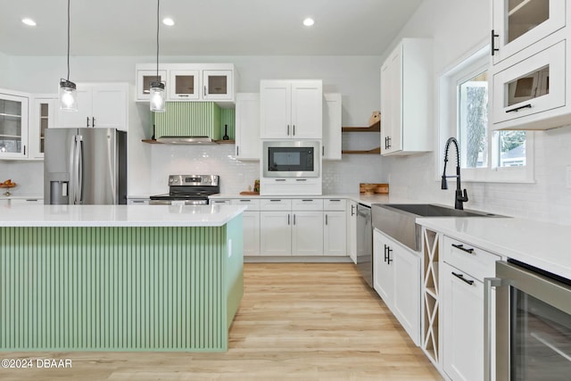 kitchen featuring white cabinetry, appliances with stainless steel finishes, decorative light fixtures, and wine cooler