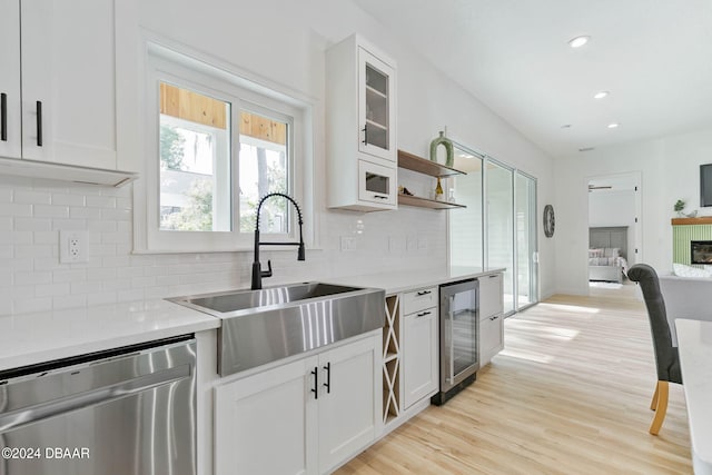 kitchen with white cabinetry, wine cooler, sink, stainless steel dishwasher, and light wood-type flooring