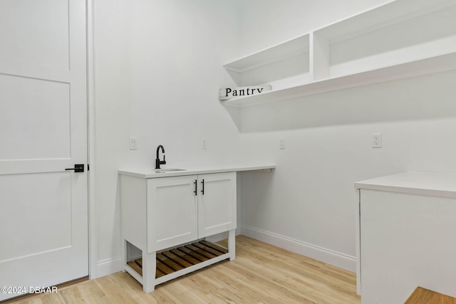 laundry area featuring light wood-type flooring and sink