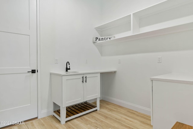 6 Willow Trce, Flagler Beach, FL 32136 - laundry room featuring light wood finished floors, baseboards, and a sink