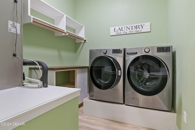 clothes washing area featuring light wood-type flooring and washing machine and dryer