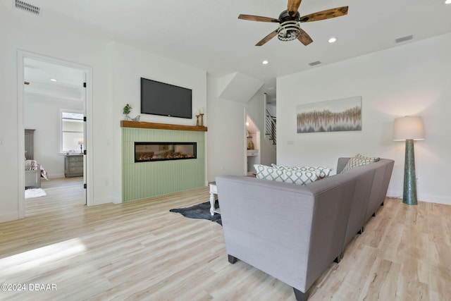 living room with light hardwood / wood-style flooring and ceiling fan