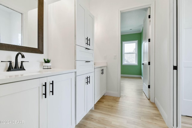 bathroom featuring hardwood / wood-style floors, vanity, and ornamental molding