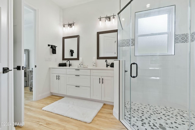 bathroom featuring hardwood / wood-style floors, walk in shower, and vanity