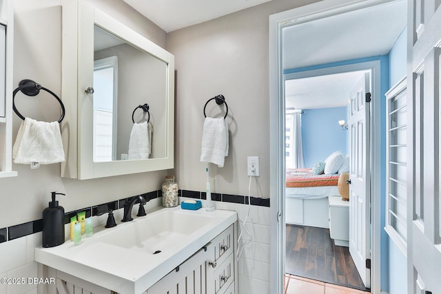 2800 N Atlantic Ave Unit 206, Daytona Beach, FL 32118 - ensuite bathroom featuring tile walls, vanity, and a wainscoted wall