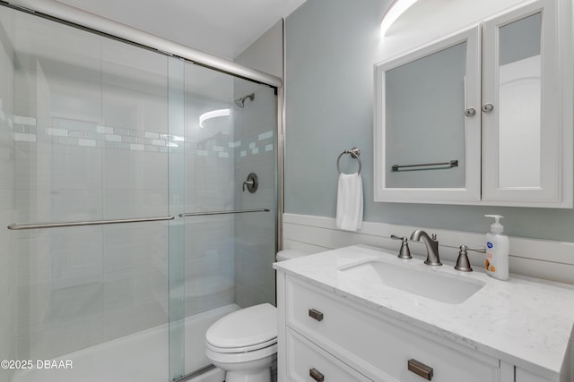 bathroom with toilet, walk in shower, and vanity