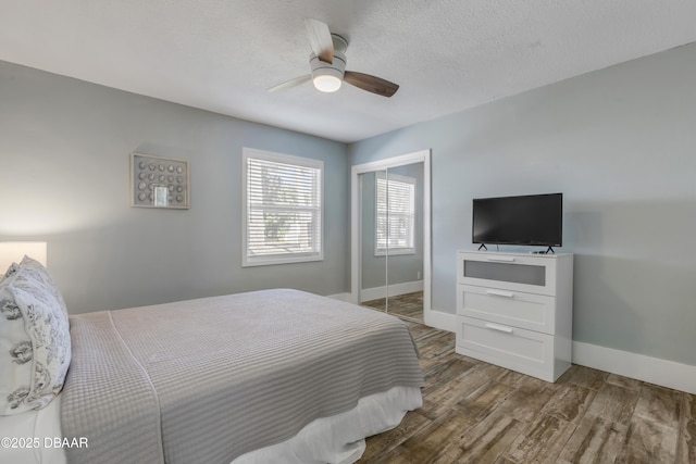 bedroom featuring ceiling fan, dark hardwood / wood-style floors, and a textured ceiling