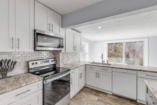 kitchen featuring light stone countertops, sink, white cabinets, and appliances with stainless steel finishes