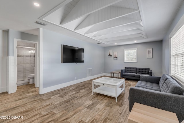 living room featuring vaulted ceiling and light hardwood / wood-style floors