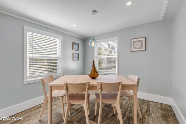 dining room featuring ornamental molding, lofted ceiling, and wood-type flooring