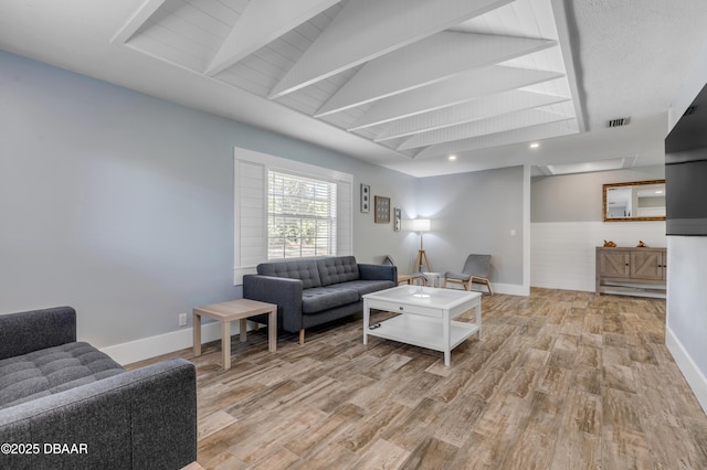 living room with vaulted ceiling and light wood-type flooring