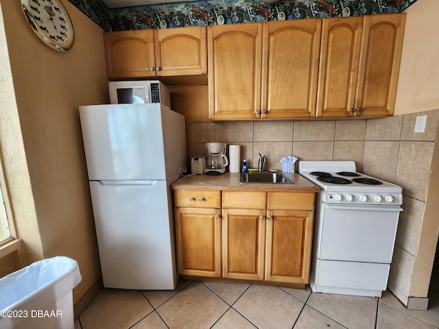 1233 S Atlantic Ave Unit 211, Daytona Beach, FL 32118 - kitchen with white appliances, light tile patterned floors, light countertops, and decorative backsplash