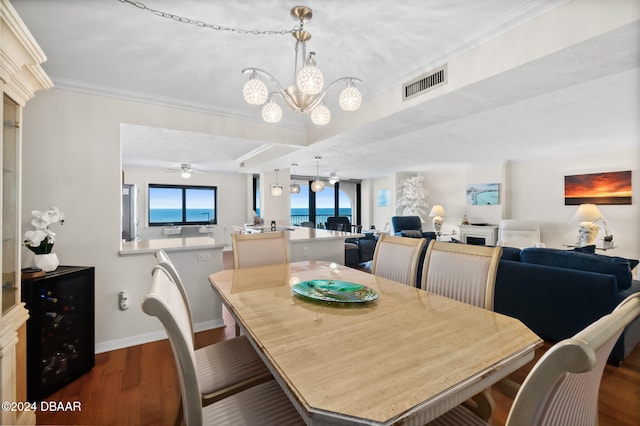 dining space with ornamental molding, ceiling fan with notable chandelier, and hardwood / wood-style flooring